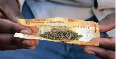  ?? Picture : SIMONE KLEY ?? CANNABIS: A man crushes dagga in a R20 note before rolling it to smoke.