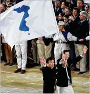  ?? CHANG W. LEE / THE NEW YORK TIMES ?? Pak Jang Choo of North Korea and Chung Eun-Soon of South Korea march with a unified emblem of the two Koreas during the opening ceremony of 2000 Summer Olympics in Sydney, Australia.