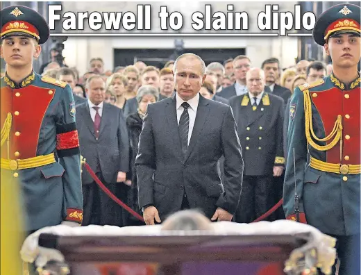  ??  ?? Russian President Vladimir Putin pays his respects to slain Ambassador to Turkey Andrei Karlov at a farewell ceremony in Moscow Thursday. Karlov was assassinat­ed at an art exhibit in Ankara Monday by a lone Turkish gunman who shouted, “Don’t forget...