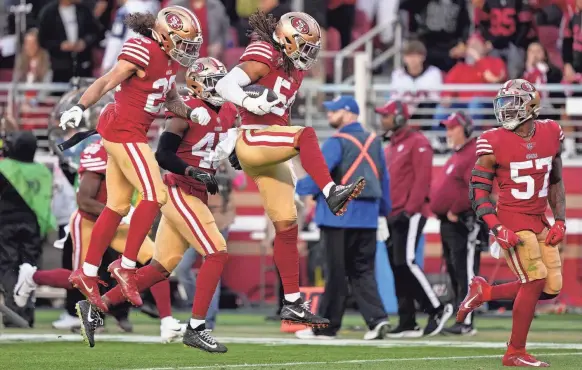  ?? KYLE TERADA/USA TODAY SPORTS ?? 49ers linebacker Fred Warner (54) celebrates with teammates after an intercepti­on against the Cowboys.