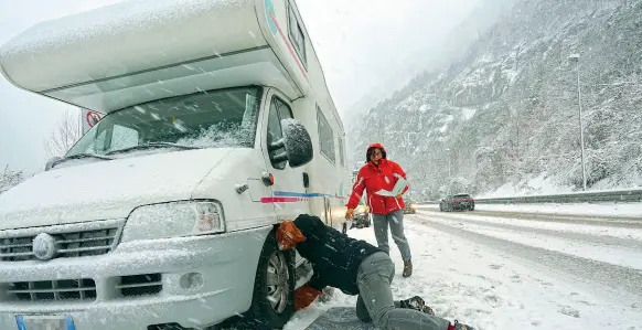  ??  ?? Verso Cortina Il piano neve stavolta ha retto: respinti gli automobili­sti che viaggiavan­o sprovvisti di catene. Qui a fianco, il proprietar­io di un camper impegnato a mettere le catene