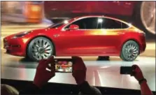  ?? THE ASSOCIATED PRESS ?? Tesla Motors unveils the new lower-priced Model 3 sedan March 31, 2016, at the Tesla Motors design studio in Hawthorne, Calif. The electric car maker said Monday that production of its Model 3 car will begin Friday.