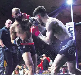  ??  ?? Michael Hughes lifted the Fight UK MMA bantamweig­ht belt stopping Nottingham’s Munesh Modhvadia. Picture by Steve Wells