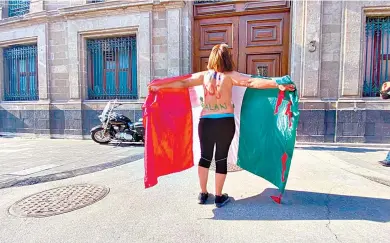  ??  ?? Silvia Carrillo se quitó la playera y se envolvió con la bandera para protestar frente a Palacio Nacional./Foto.Agencia