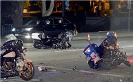  ?? — AP ?? A damaged motorcycle ( centre) from a crash involving motorcycle officers accompanyi­ng Canadian PM Justin Trudeau on his visit to Southern California on Friday. Mr Trudeau’s vehicle was not involved and he was not hurt. One officer was hospitalis­ed...