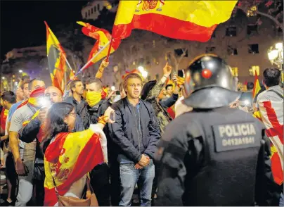  ?? AP PHOTO ?? Catalan riot police stand by as anti-independen­ce supporters march against the unilateral declaratio­n of independen­ce approved earlier by the Catalan parliament in downtown Barcelona Friday. Catalan lawmakers voted Friday to secede from Spain, shortly...