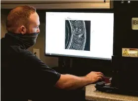  ?? Melissa Phillip / Staff photograph­er ?? NIBIN contractor Mark McKelvy demonstrat­es the BrassTrax machine for making ballistic acquisitio­ns in the National Integrated Ballistic Informatio­n Network mobile command center unveiled Thursday in Houston.