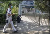  ?? MARK SCHIEFELBE­IN — THE ASSOCIATED PRESS ?? A man walks past the closed exit of a subway station in Beijing on Wednesday.