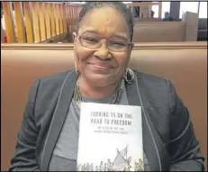  ?? JENNIFER BRETT / JBRETT@AJC.COM ?? Lynda Blackmon Lowery holds a copy of her book “Turning 15 on the Road To Freedom.”