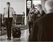  ?? Evans Caglage / Tribune News Service ?? A pilot walks the councourse at DFW Internatio­nal Airport in Dallas. American Airlines plans to cut its workforce this fall with layoffs and furloughs.