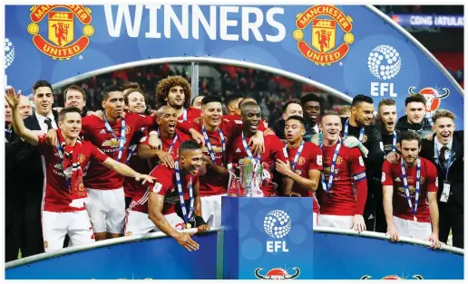  ??  ?? Manchester United’s players celebrate with the trophy on the pitch after their victory in the English League Cup final football match between Manchester United and Southampto­n at Wembley stadium in north London on Sunday. (AFP)