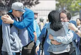  ??  ?? FAMILIES reunite after the school lockdown was lifted, about three hours after the shooting. Authoritie­s said it is too early to determine a motive for the attack.