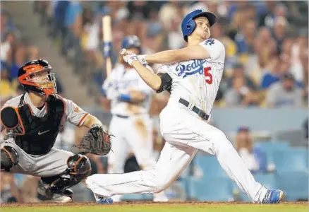  ?? Photograph­s by Gina Ferazzi Los Angeles Times ?? THE BASEBALL never gets to Giants catcher Nick Hundley as Corey Seager delivers a two-run home run in the seventh inning off reliever Josh Osich to give the Dodgers a 6-4 lead. Seager also hit a solo homer in the first inning and has 18 for the season.
