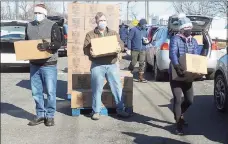  ?? Ned Gerard / Hearst Connecticu­t Media ?? Volunteers load food into vehicles during the CT Food Bank/Foodshare food donation at Calf Pasture Beach in Norwalk on Feb. 17.