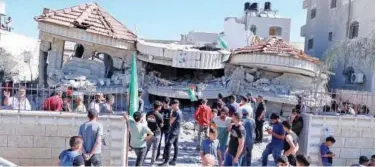  ?? Agence France-presse ?? ↑
Palestinia­ns gather outside a building that belonged to Montasser Shalabi, after it was demolished by Israeli forces near Ramallah on Thursday.