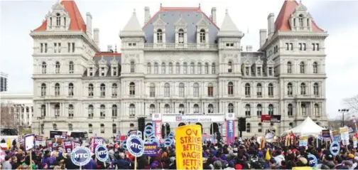  ??  ?? ALBANY: In this March 15, 2016 file photo, the state Capitol provides a backdrop as supporters of a $15 minimum wage rally at the Empire State Plaza. — AP