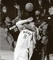  ?? Mark J. Terrill / Associated Press ?? The Bucks’ Brook Lopez, center, fights for a rebound with the Heat’s Jimmy Butler, left, and Bam Adebayo.