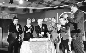  ??  ?? Kobus (third left), who is joined by Joe (fourth left) and other distinguis­hed guests, cuts the cake to celebrate Sanlam’s 100th birthday.