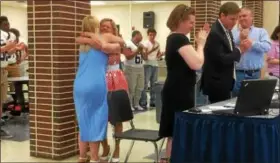  ?? EVAN BRANDT — DIGITAL FIRST MEDIA ?? Pottstown School Board member Polly Weand gets a hug from her daughter Betsy while the school board and audience applaud. Weand led the successful three-year effort to raise the money to replace the high school stadium lights at Grigg Memorial Field.