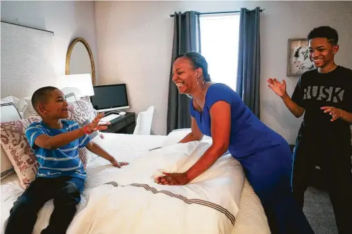  ?? Mark Mulligan photos / Houston Chronicle ?? Arica Bibbs smiles as she sees her new bed with her sons in her newly furnished and redesigned apartment.