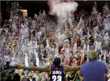  ?? AP Photo/Mark Duncan ?? In this 2008 file photo, fans toss confetti to mimic Cleveland Cavaliers’ LeBron James’s pre-game chalk toss before an NBA basketball game against the Washington Wizards in Cleveland.