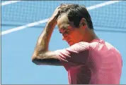  ?? MARK BAKER — ASSOCIATED PRESS ?? Defending champion Roger Federer wipes away sweat during a practice sessionThu­rsday ahead of theAustral­ian Open.