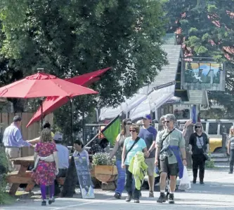  ?? MARK THIESSEN/ AP FILES ?? Tourists walking along historic Main Street in Talkeetna, Alaska. A new business on Main Street this year is The High Expedition Co., the first marijuana store, and its presence has caused a divide among residents.