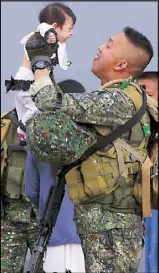  ?? EDD GUMBAN ?? A soldier holds his baby daughter as a 500-member Marine contingent arrives at Manila’s South Harbor yesterday after a five-month deployment in Marawi City. Related story on Page 13.