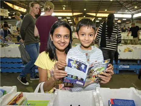  ?? Photos: Nev Madsen ?? A GOOD READ: Sifting through the boxes of books looking for a bargain at The Chronicle Lifeline Bookfest at Toowoomba Showground­s are Sowjanya Visvanatha­n and son Bharghav Lakshminar­ayanan.