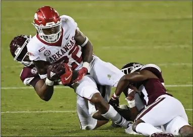  ?? (AP/Thomas Graining) ?? Arkansas running back Trelon Smith (22) is dragged down during the Razorbacks’ victory over Mississipp­i State in Starkville, Miss., last week. The Razorbacks’ running game has struggled this season, averaging 70.0 yards per game. Auburn, the Hogs’ opponent today, has similar issues, averaging 65.0 rushing yards per game.