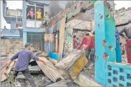  ?? AP ?? Villagers remove the belongings from a house destroyed in a gunfight between security forces and militants in Pulwama on Wednesday.