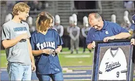  ??  ?? Former Gordon Lee pitcher Conard Broom is presented with a framed jersey as the Cleveland Indians farmhand was recently honored at halftime of a Trojans’ football game.