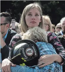  ?? FRED CHARTRAND THE CANADIAN PRESS ?? Elizabeth Hargrave, widow of firefighte­r James Hargrave of Alberta, holds her son Hudson, 6, at the Canadian Firefighte­rs Memorial.