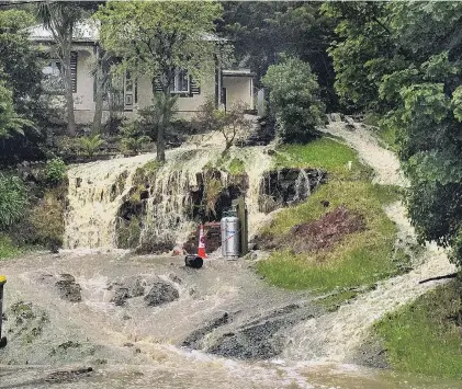  ?? PHOTO: GREGOR RICHARDSON ?? Waterfall . . . Water gushes down the hill in front of a Ravensbour­ne house yesterday.