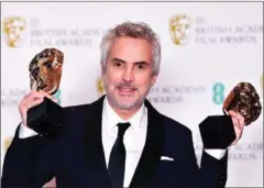  ?? AFP ?? Alfonso Cuaron poses with his Best Director and Best Film awards for at the British Academy Film Awards in London.