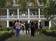  ?? GERALD HERBERT—ASSOCIATED PRESS ?? In this July 14, 2017file photo, visitors walk outside the main plantation house at the Whitney Plantation in Edgard, La. The Whitney, which documents slavery at a pre-Civil War plantation near New Orleans, draws tens of thousands of visitors annually and is known for discussing topics that other tourist plantation­s ignore. Yet even its entry in the National Register, completed in 1992before the current owner purchased it, doesn’t mention the slaves who toiled there.