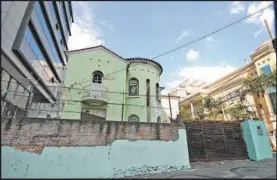  ??  ?? A “casa verde” na Avenida Olegário Maciel, uma das três ocupadas no mesmo quarteirão, abriga 12 pessoas desde janeiro. No detalhe, janela coberta precariame­nte