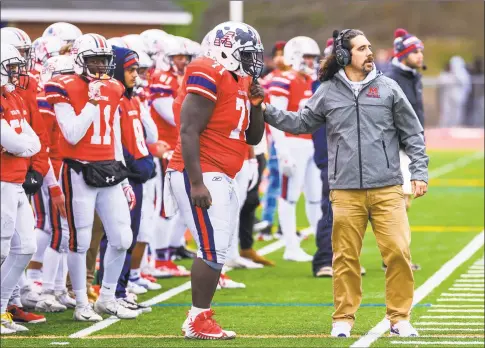  ?? Hearst Connecticu­t Media ?? McMahon football coach Jeff Queiroga with his team during a game against Norwalk on Nov. 28. The coach was in the process of growing his hair to donate to a charity that makes wigs for pediatric cancer patients. During the COVID- 19 pandemic, Queiroga and fellow McMahon teacher Nick Banas started a program that provided nearly 2,000 meals to Norwalk residents.