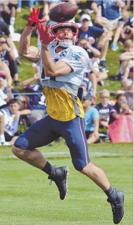  ?? STAFF PHOTOS BY CHRIS CHRISTO ?? FOCUS ON FOOTBALL: Julian Edelman, who will miss the first month of the regular season, hauls in a pair of passes during yesterday’s training camp practice at Gillette Stadium.