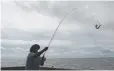  ?? Gerald Herbert, Associated Press file ?? Tim Hitchens pulls in a fish from a pier in Biloxi, Miss., on Sept. 5.