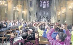  ??  ?? &gt; People raising their hands to show they have no weapons inside the Notre- Dame Cathedral. They were confined inside the church as police took on the attacker