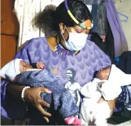  ?? ?? FLASHBACK . . . First Lady Auxillia Mnangagwa cradles the then three -week-old twin girls in April last year when she brought them infant formula, feeding bottles, diapers, baby clothes, baby blankets among other things for their upkeep following the death of their mother