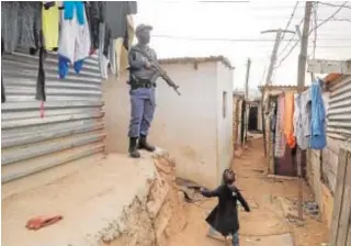  ?? // AFP ?? Un policía vigila durante una operación contra el pillaje en Johannesbu­rgo