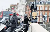  ??  ?? The scooter gang was captured by a photograph­er on Putney Bridge as they held up rush hour traffic and attempted to remove the camera from the scaffoldin­g