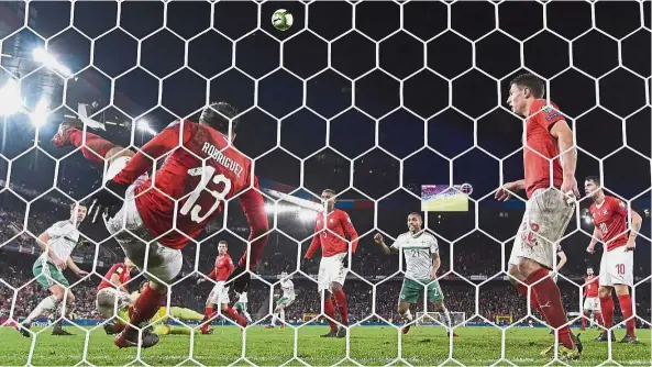  ??  ?? Timely interventi­on: Switzerlan­d defender Ricardo Rodriguez (left) clearing the ball off the line during the World Cup playoff second-leg clash against Northern Ireland at the St Jakob-Park Stadium in Basel on Sunday. The match ended 0- 0, giving...