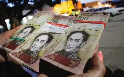  ??  ?? COLOMBIA: A woman shows wads of 100-bolivar-bills to change in La Parada, municipali­ty of Villa del Rosario, Norte de Santander department, Colombia, in the border with Venezuela yesterday. Venezuelan President Nicolas Maduro on Sunday signed an emergency decree ordering the country’s largest banknote, the 100 bolivar bill, taken out of circulatio­n to thwart “mafias” he accused of hoarding cash in Colombia. —AFP