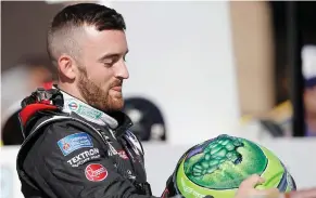  ?? (Photo by Alex Gallardo, AP) ?? Austin Dillon puts on his helmet on pit row prior to the qualifying session for today’s race in Fontana, Calif.