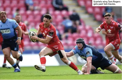  ??  ?? Scarlets wing Tom Rogers gets past Seb Davies.