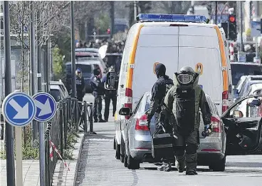  ?? PATRIK STOLLARZ / AFP / GETTY IMAGES ?? Bomb squad personnel arrive to take part in an anti-terrorist operation on tramway tracks in the Schaerbeek-Schaarbeel district in Brussels on Friday.