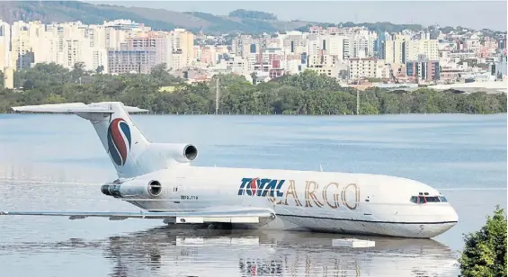  ?? REUTERS ?? Lago. Un avión de cargas quedó varado en una de las pistas del aeropuerto de Porto Alegre, donde el agua alcanzó varios metros de altura.